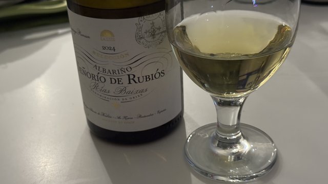Bottle of Señorío de Rubiós Albariño beside a poured glass, Rías Baixas label